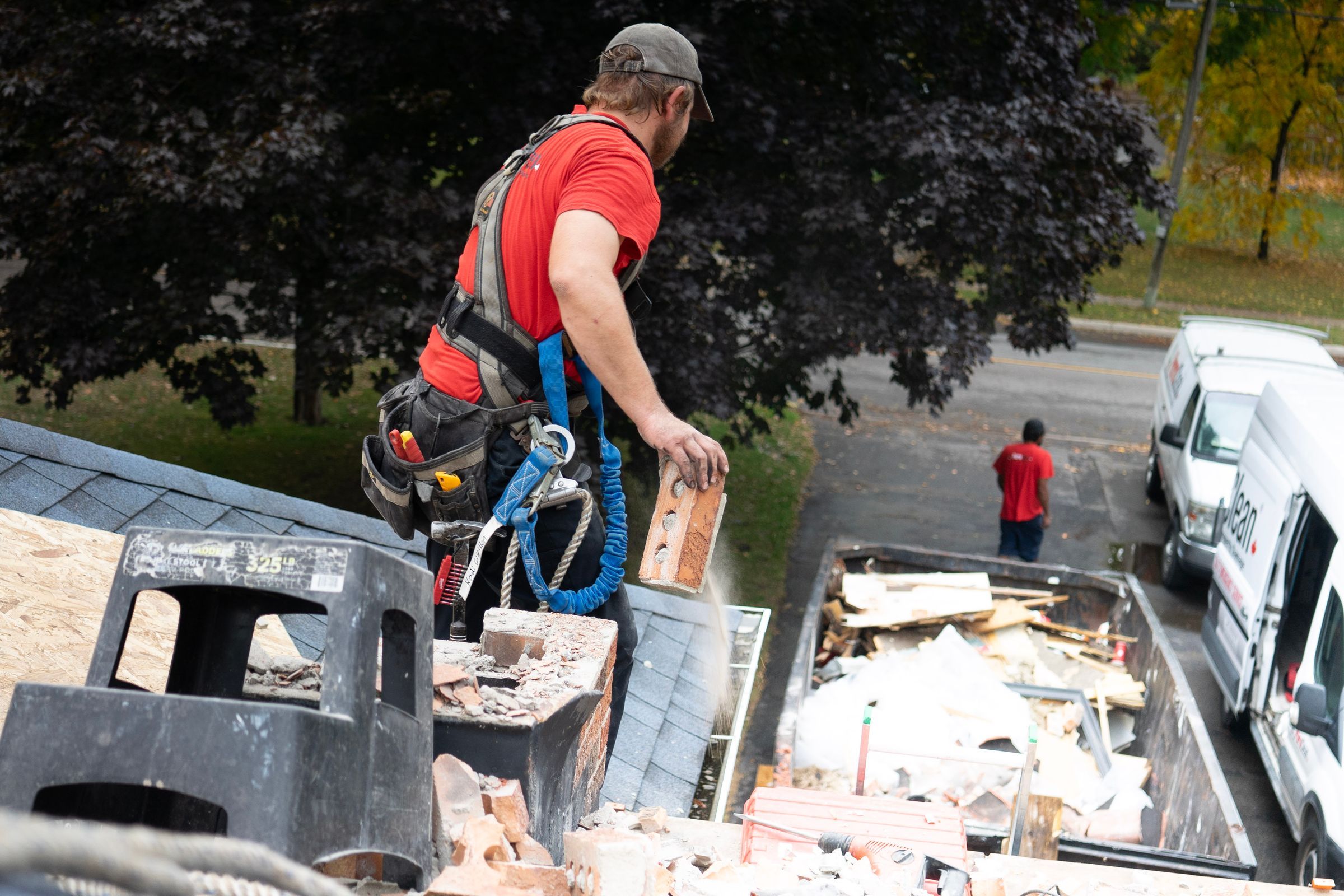 Roofer loading old roofing debris into a truck