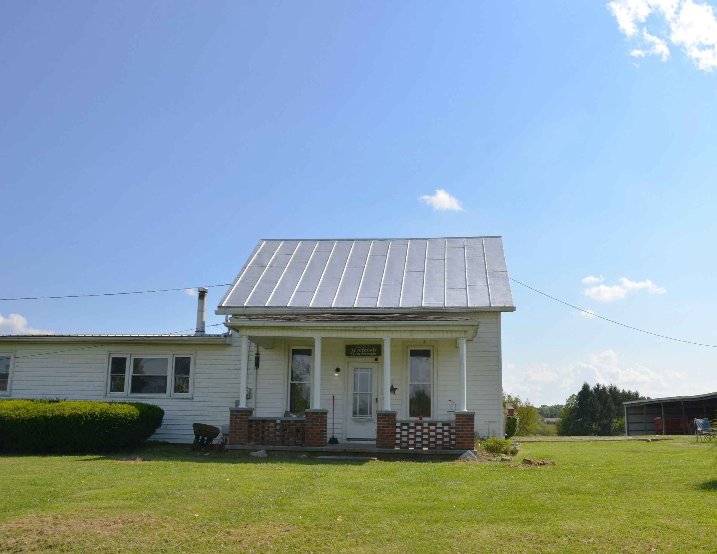 White farmhouse with a new standing-seam metal roof