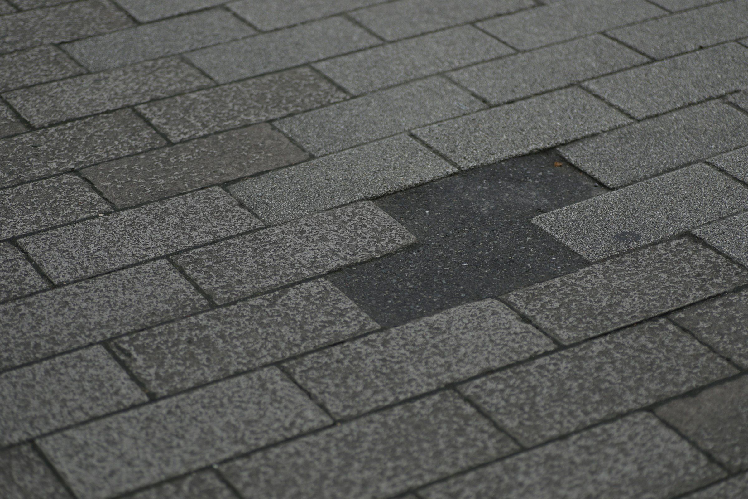 Asphalt roof with several shingles torn off by wind